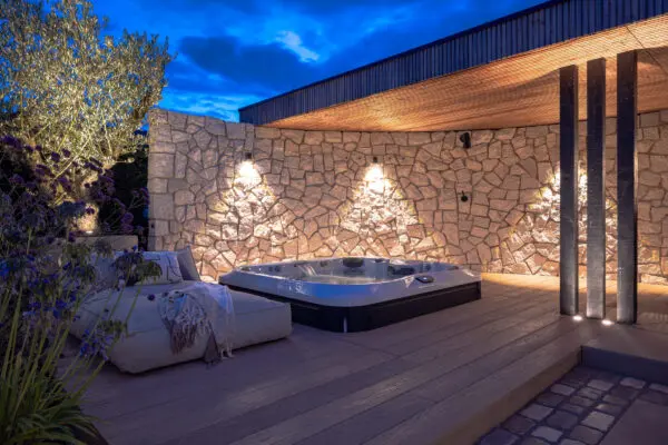 Luxe tuin met jacuzzi, natuurstenen wand en ademend lichteffect van buitenverlichting.Fotografie: Dion Doornik. Tuinontwerp: Biesot Tuinen.