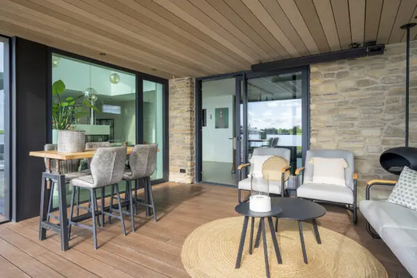 Overdekt terras met Moniga Steenstrips en moderne buitenruimte