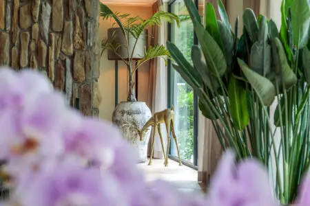 Lamp en plant in woonkamer met detail van verticale plaatsing steenstrips