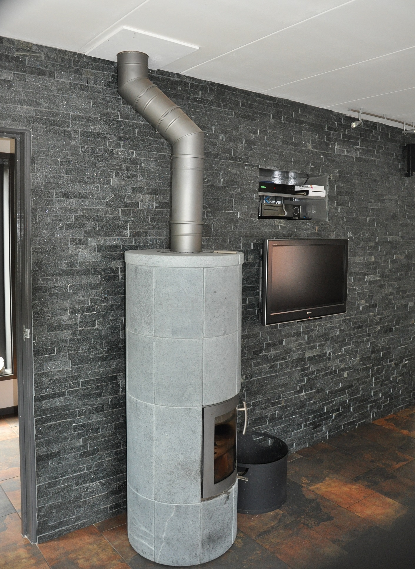 Woonkamer wand bekleed met Natuursteenstrips Zwart Kwartsiet. 