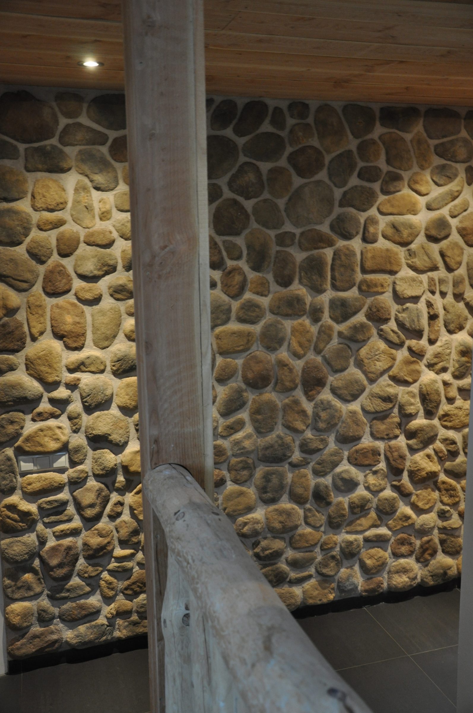 Detailfoto. Trapleuning van geschilde boomstammen in combinatie met sierstrips.