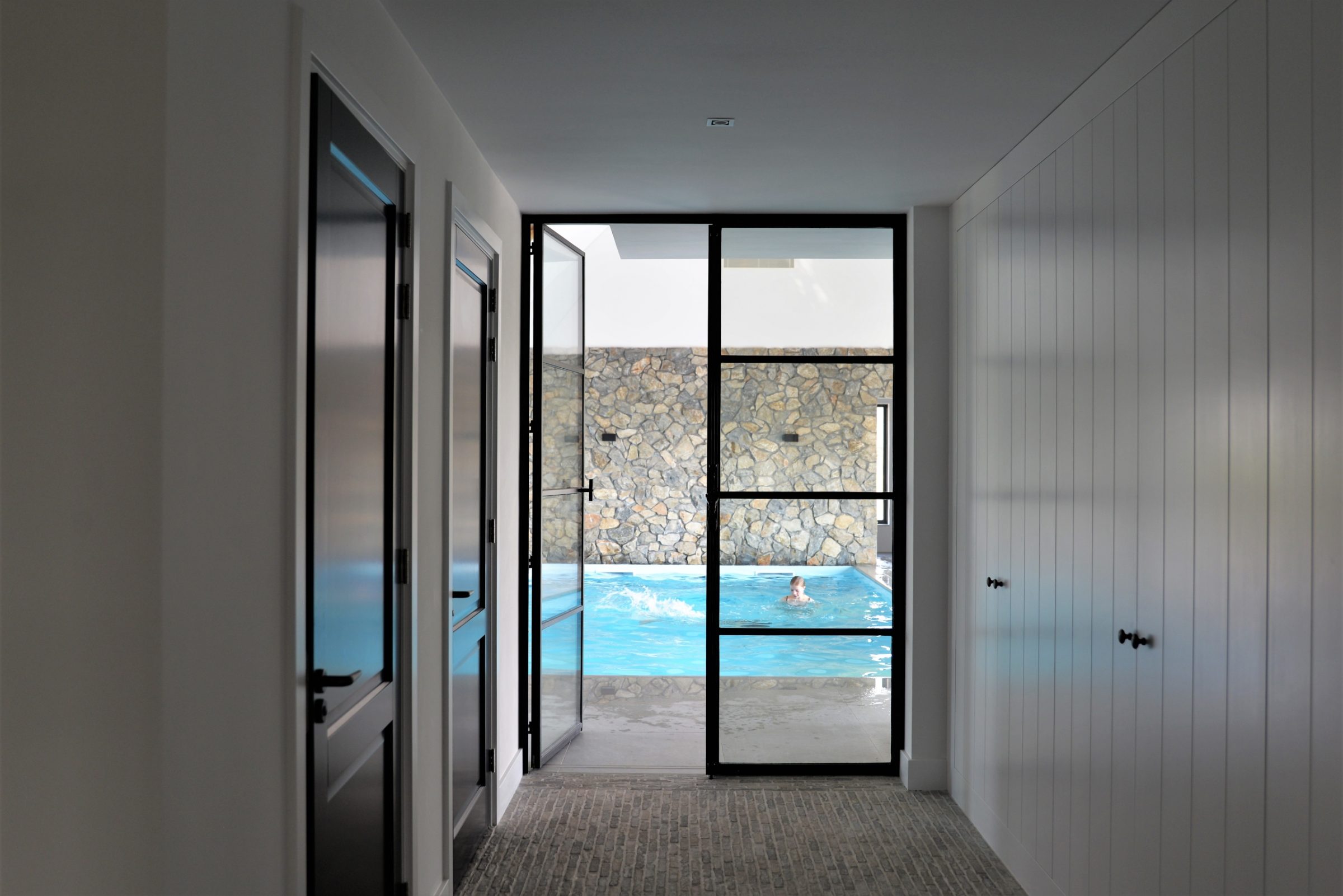 Brokken natuurstenen wand - zwembad. Ontwerp Jestyle Interieur.