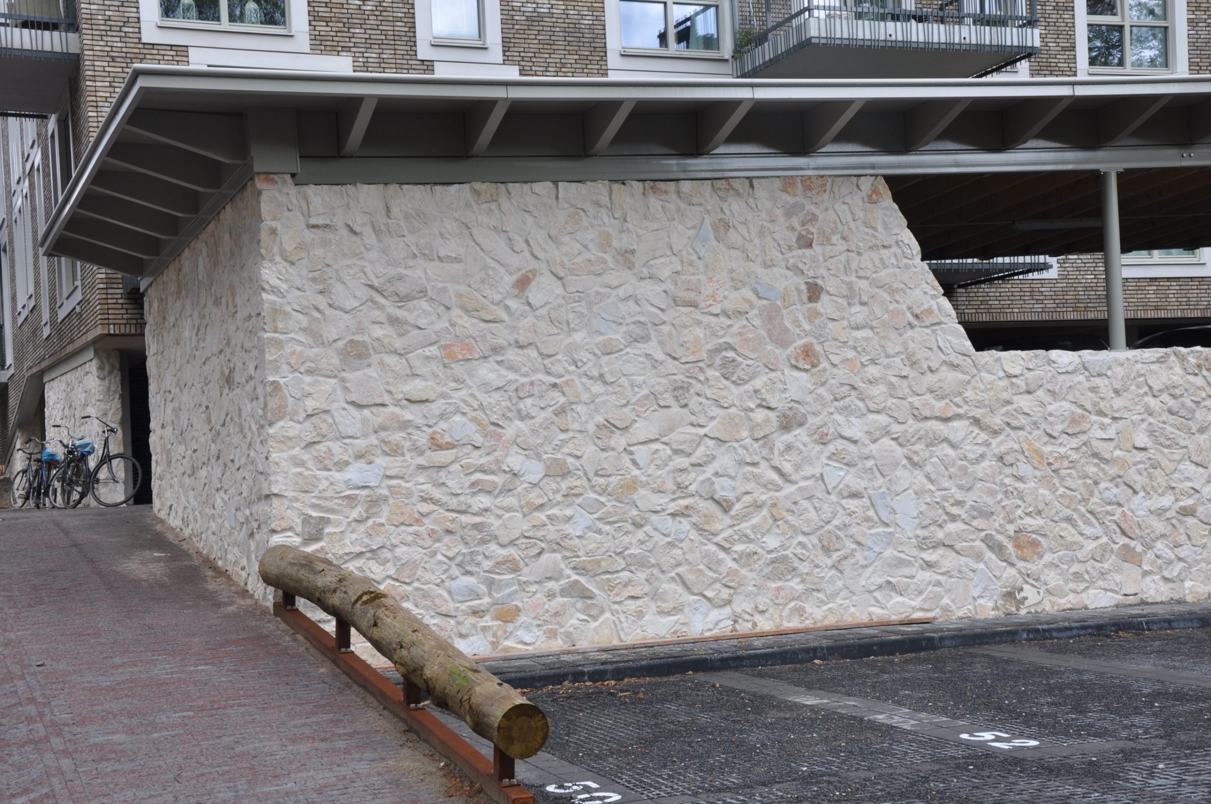 Rocks Melan bij appartementengebouw Kerkebosch, Natuurstenen plint.