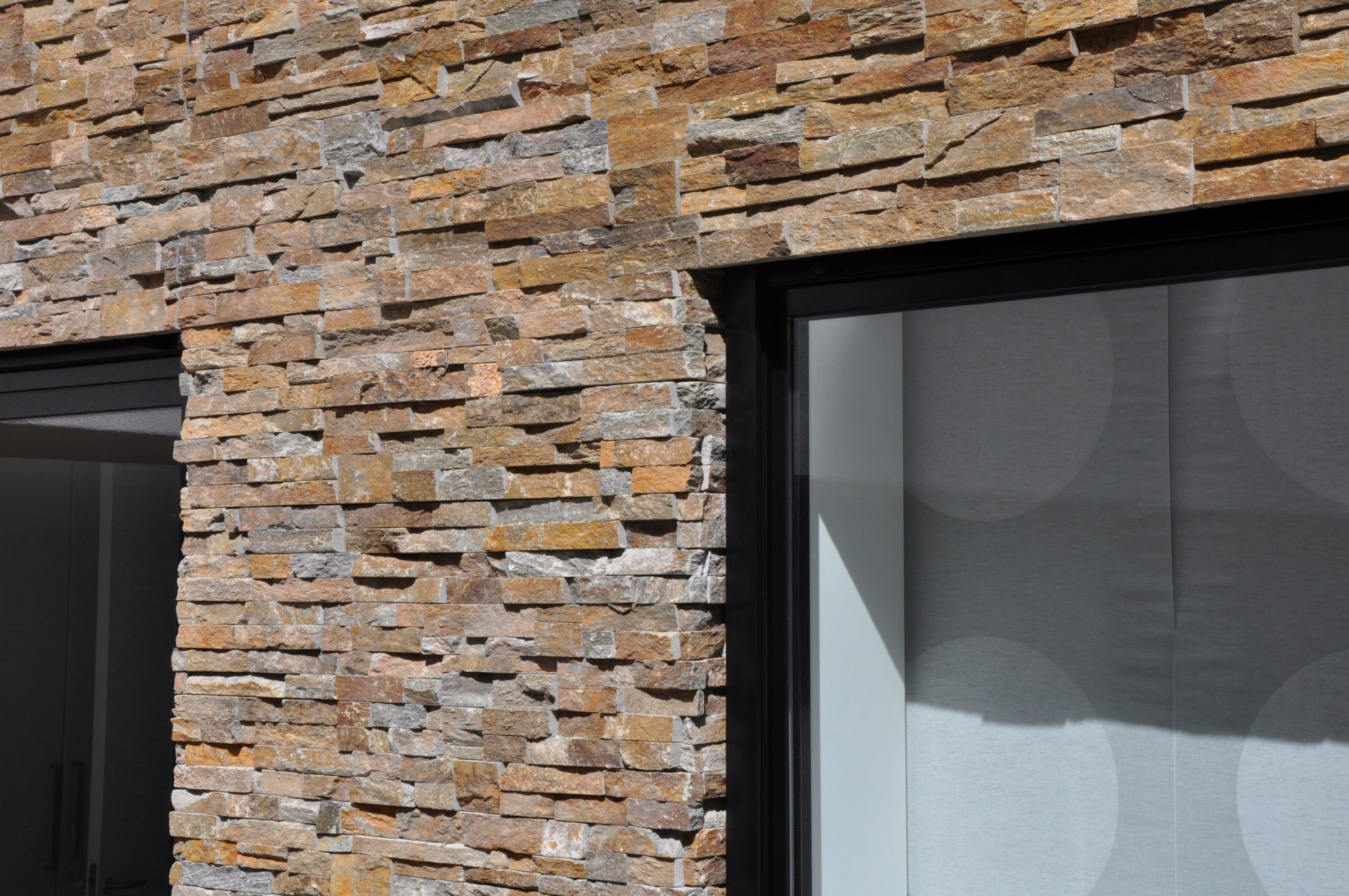 Duurzame woning met stuc en Natuursteenstrips Brons Rustiek Kwartsiet.