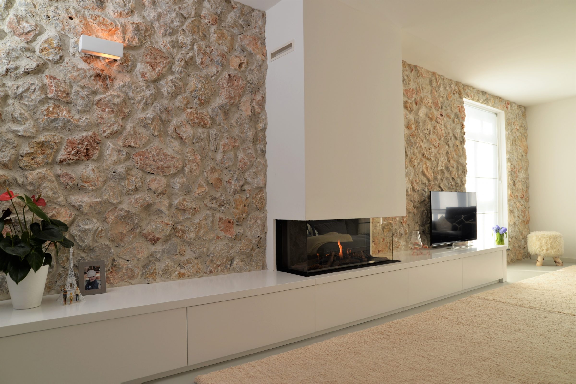 Muur bekleed met Natuurstenen - haard wit gestuckt. Natuurstenen voor de open haard