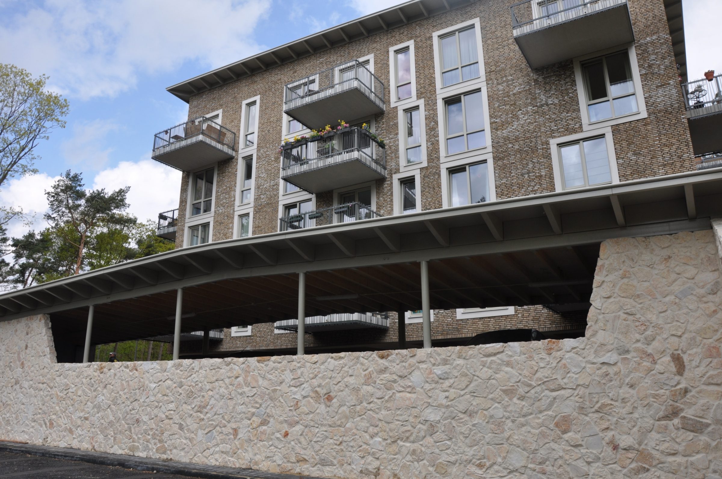 Rocks Melan bij appartementengebouw Kerkebosch, Natuurstenen plint.