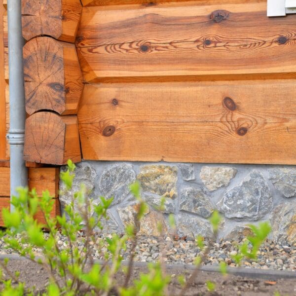 Natuursteen op de plint van houten woning.