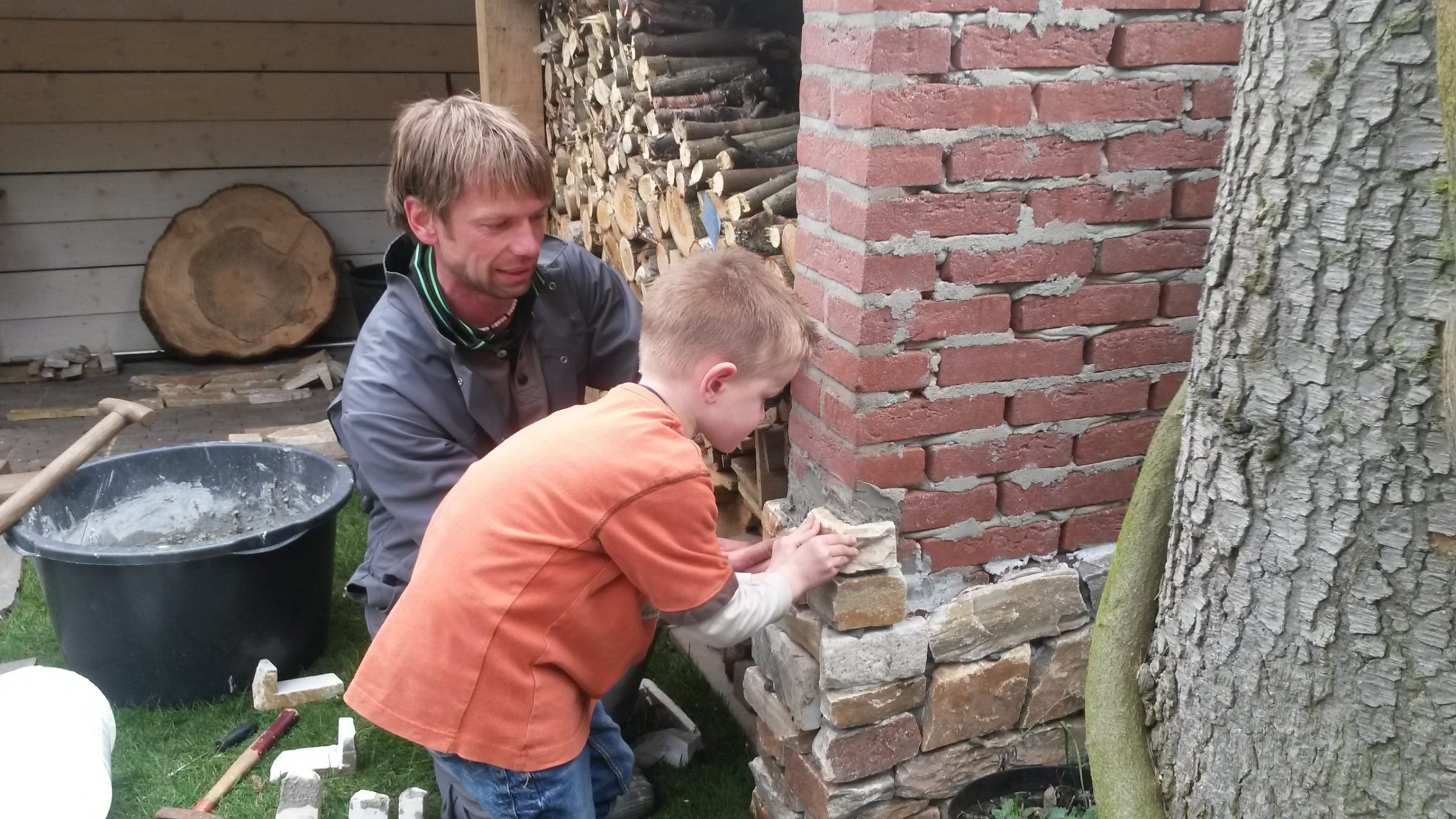 Henrico samen met zijn zoon - steenstrips plaaten voor het houthok.