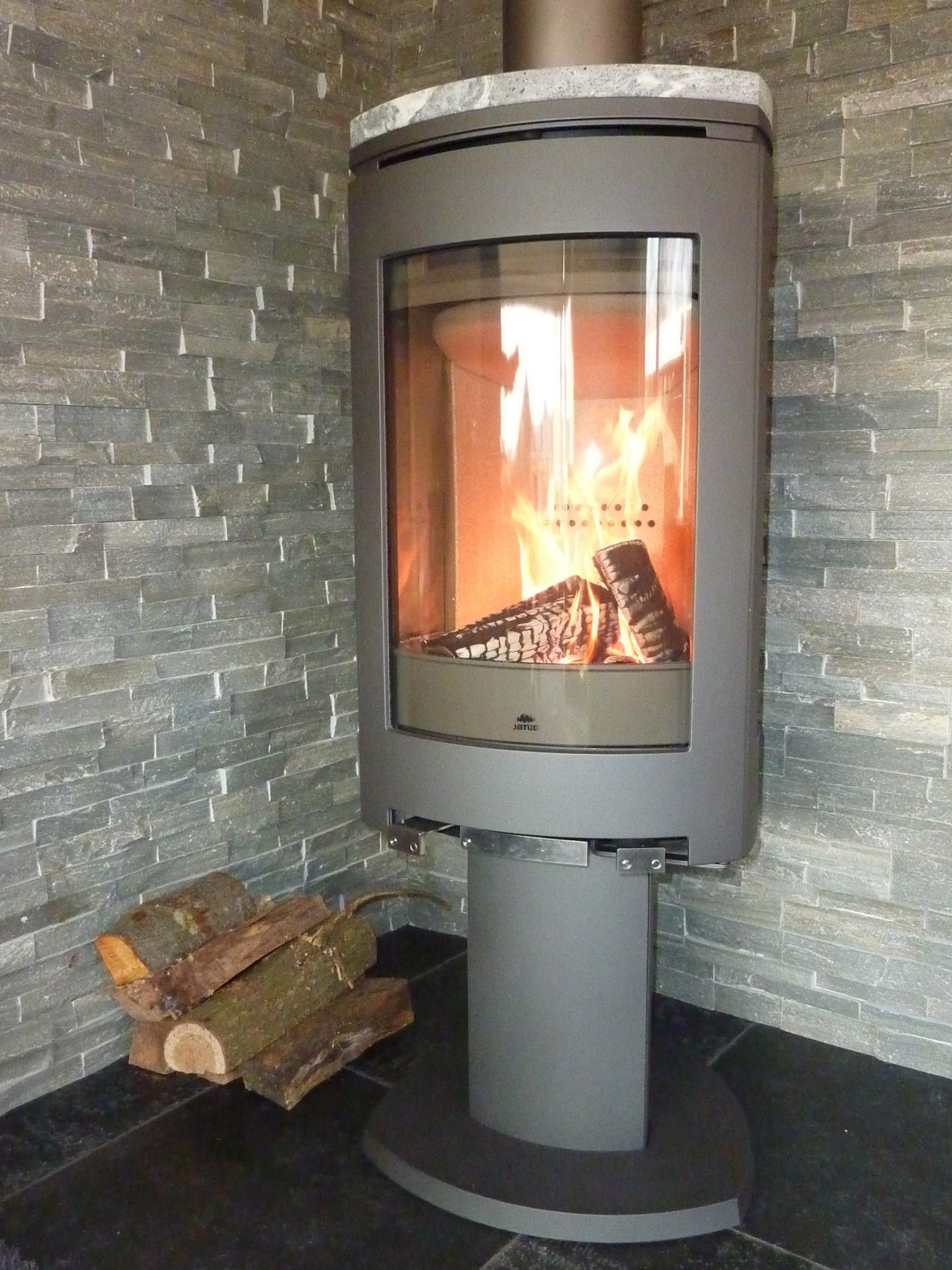 Muur binnen omkleedt met natuurstenen Steenstrips Grijs Kwartsiet in combinatie met de moderne haard.