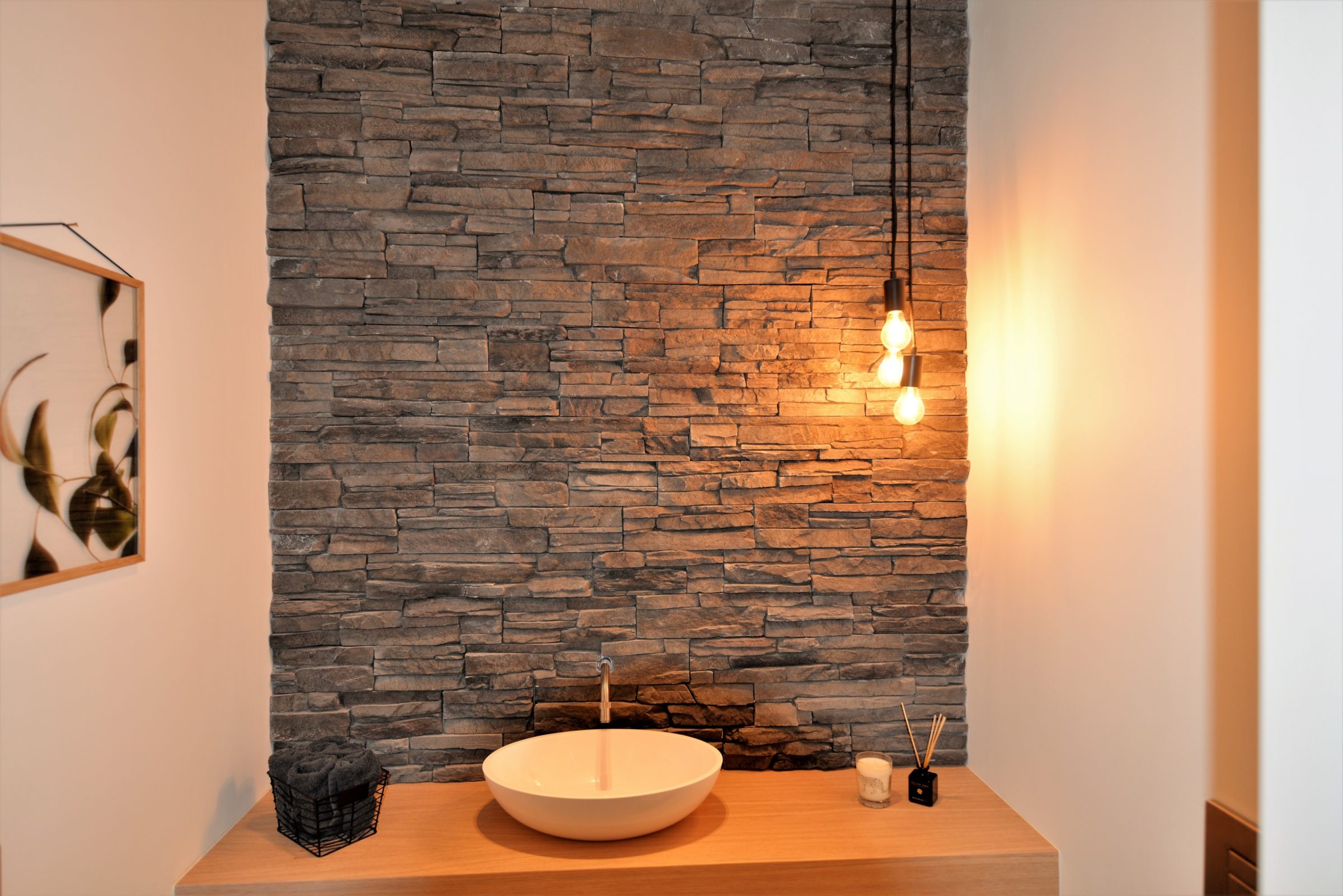 Toilet toepassing, achterwand wastafel voorzien van dezelfde steenstrips als de gevelbekleding.