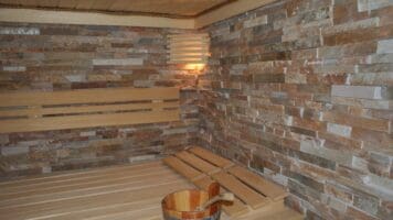 Natursteenstrips Oranje Kwartsiet. Verwerkt als wandbeklding in de sauna.