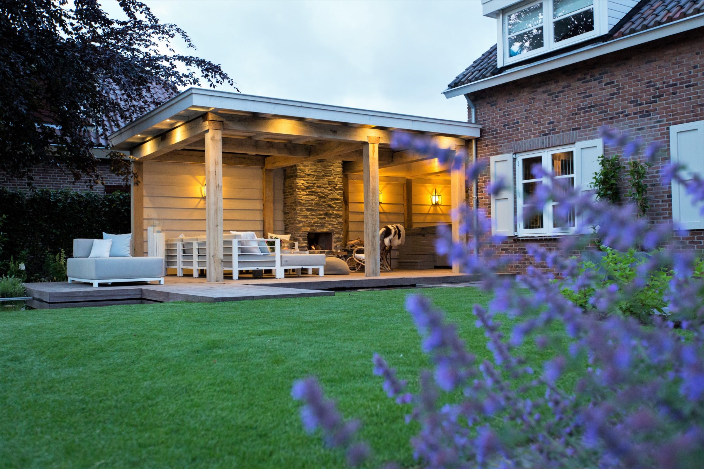 Veranda met natuurstenen muur en open haard.