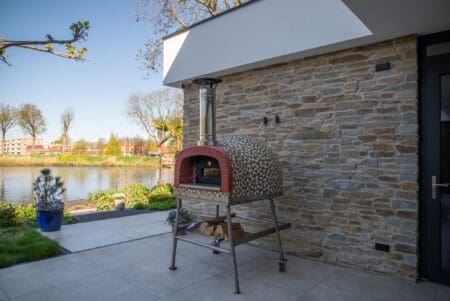 Pizzaoven op terras bij een gevel met Rocks Pedro natuursteenstrip