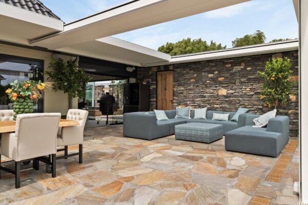 Zomerse veranda met een flagstone terras en een geopietra wand