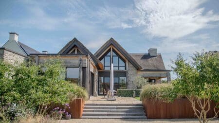 Tuinzijde van woning met rieten dak en Cascata steenstrips
