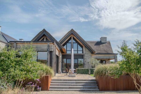 Tuinzijde van woning met rieten dak en Cascata steenstrips