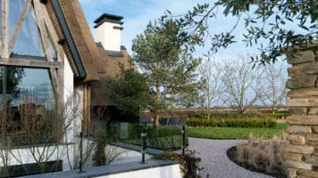 Tuinmuur met Steenstrips Luxe villa Rieten kap