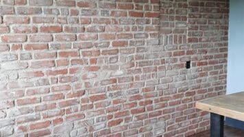 Woonkamer met industriële baksteenstrips muur