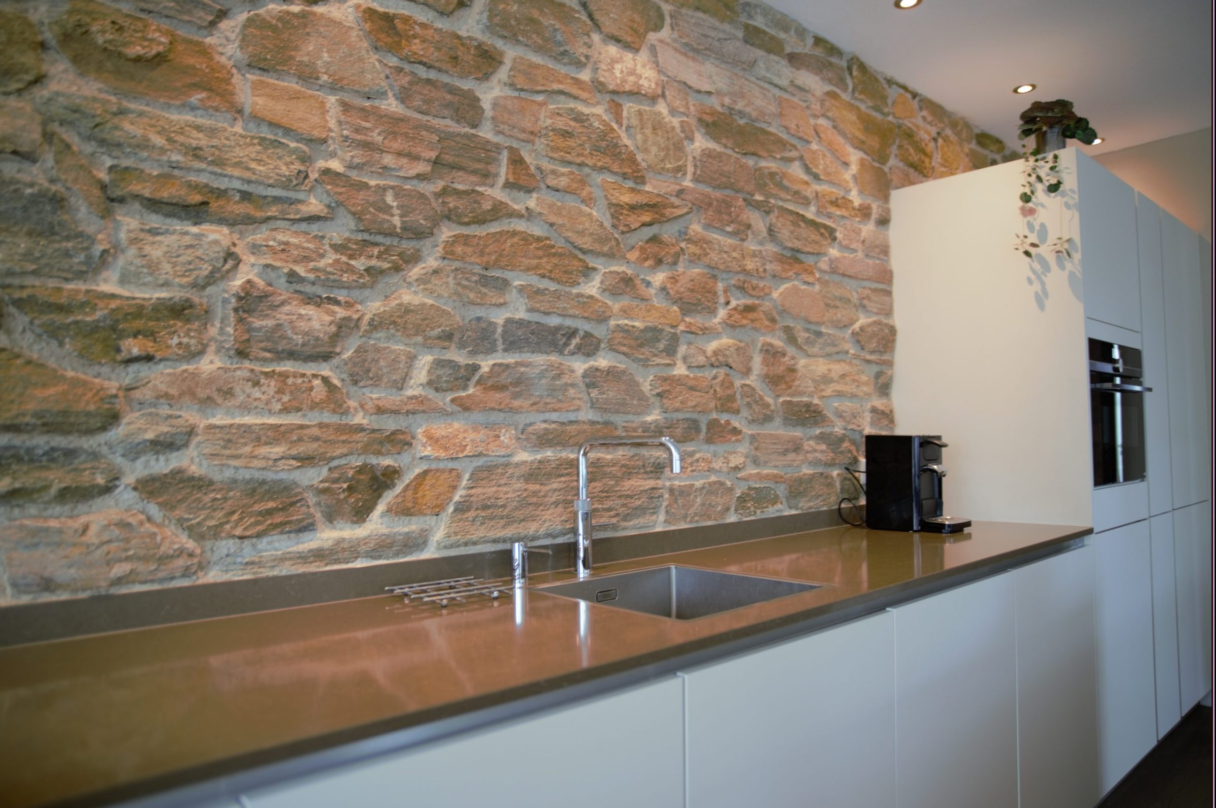 Wand van Natuurstenen Rocks Brons in de moderne keuken.