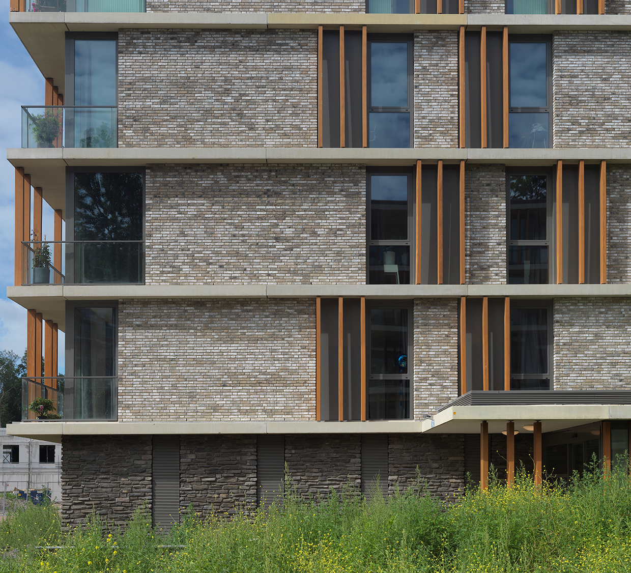 Zijgevel van het appartementencomplex met Steenstrips
