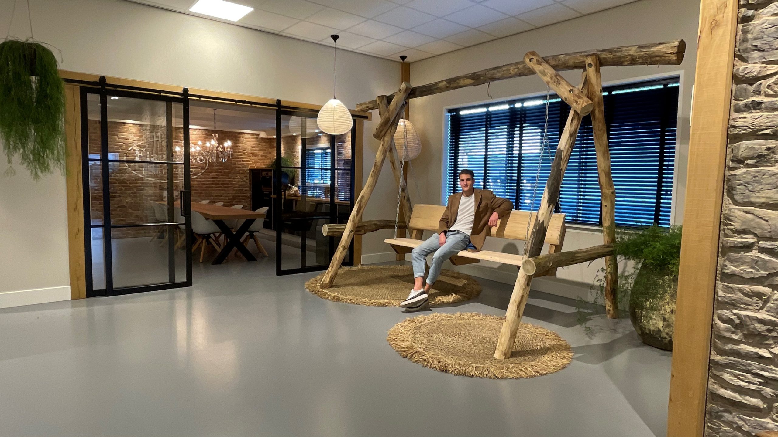 Medewerker Rutger op de schommel in de Showroom