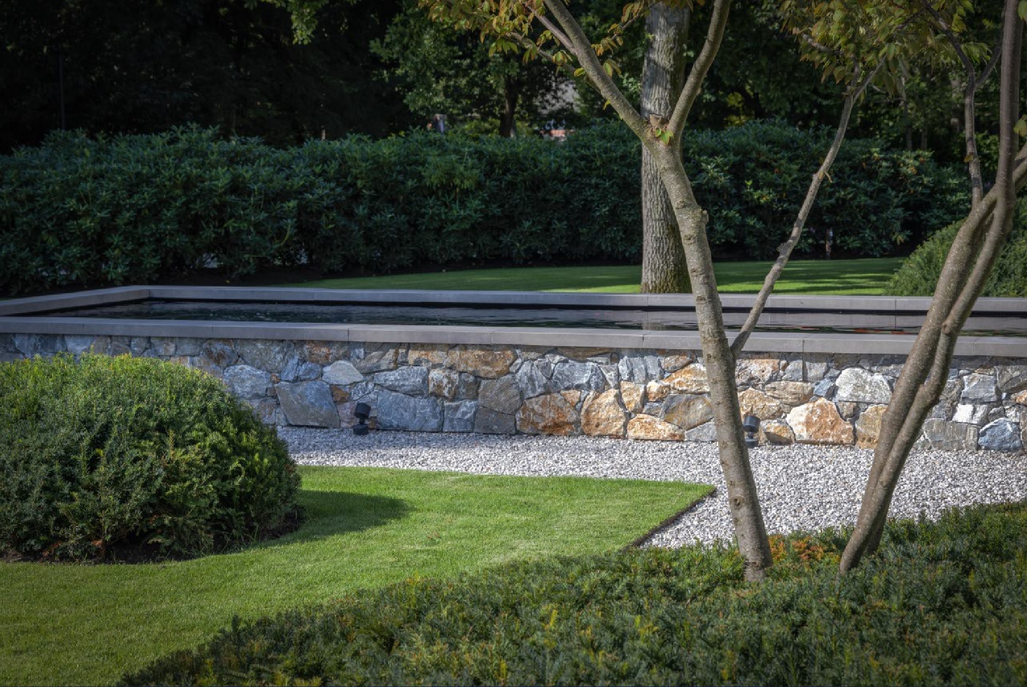 Ruwe Rocks tegen tuinmuur | Tuinontwerp: Björn Meulenberg | Fotografie: Hans Gorter