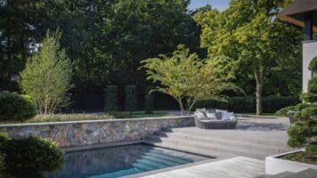 Tuinmuren, vijvermuren en zwembadmuren rondom de rietgedekte villa met Natuursteen Rocks Akkron