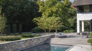 Tuinmuren, vijvermuren en zwembadmuren rondom de riet gedekte villa met Natuursteen Rocks Akkron