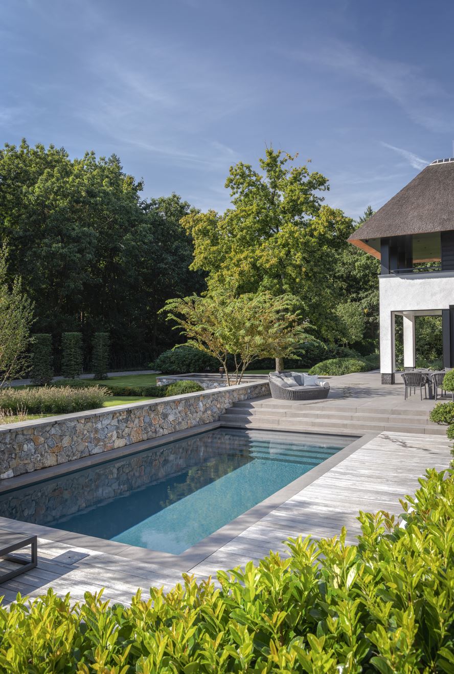 Tuinmuren, vijvermuren en zwembadmuren rondom de riet gedekte villa met Natuursteen Rocks Akkron